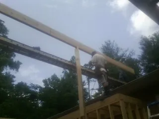 Carpenter setting a ridge beam over a new addition frame — Ice Dam Removal by Roofing Brothers in Bobtown