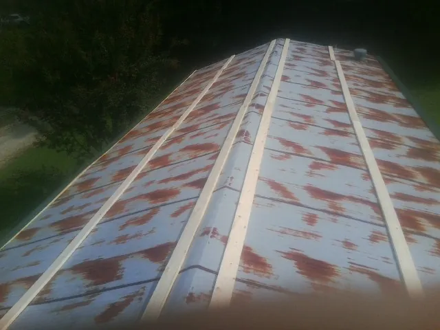 Rusted metal roof panels with new wood purlins before replacement — Storm Damage Roof Repair in Bobtown by Roofing Brothers