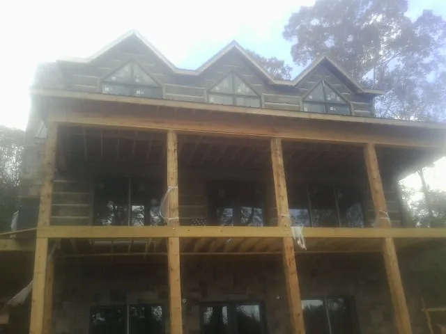 Dormers and porch framing on a large log home under construction — Roof Coating work by our crew in Bobtown